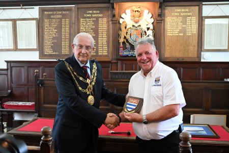 mayor Cllr Philip Evans presenting a commemorative town shield to volunteer Lifeboat Operations Manager Mark Colley.